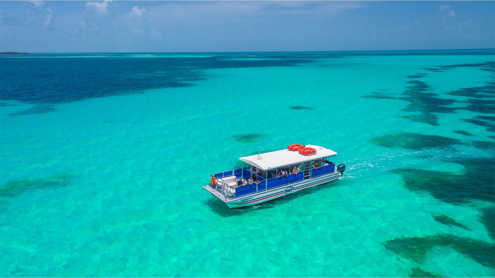 Boat on turquoise ocean under a clear blue sky.